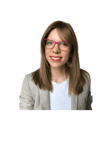 A woman with bright red glasses and lipstick, in a blazer and white teeshirt.
